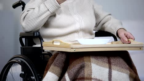 Lonely-elderly-woman-in-wheelchair-eating-dinner-and-crying,-health-problems