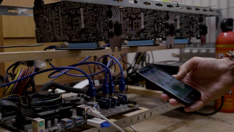 Minero-ingeniero-joven-viendo-el-proceso-de-software-minero-en-teléfono-inteligente-conectado-a-la-plataforma-de-minería-cryptocurrency