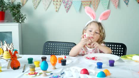 Pequeña-niña-comiendo-huevo-de-Pascua-pelado-y-sonriendo