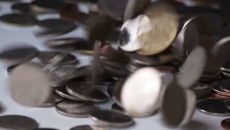 close-up-slow-motion-footage-of-money-coins-falling-to-pile-of-coins-on-white-floor.-business,-financial-for-money-saving-or-investment-concept