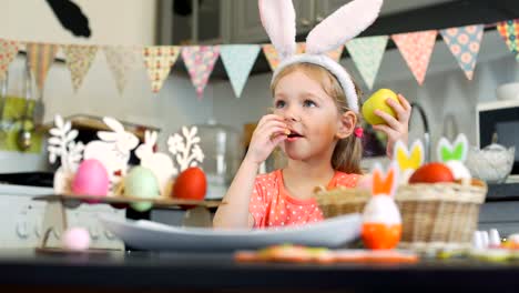 Pequeña-niña-comiendo-galletas-y-manzana-en-Pascua