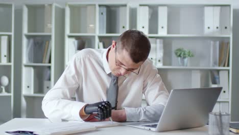 Businessman-with-Prosthetic-Hand-Writing-Note