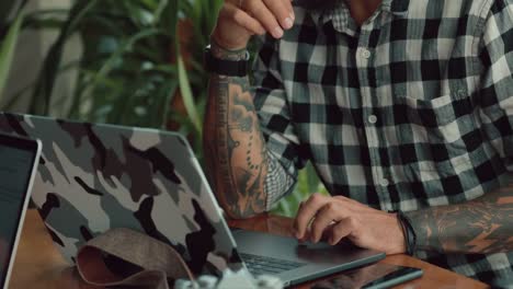 Stylish-handsome-man-photographer-working-by-laptop-computer-in-cafe