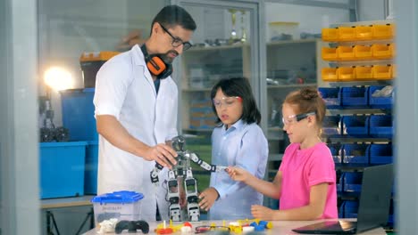 Ingenieur-mit-Schulkindern-studiert-innovative-Robotertechnologien-im-Science-Club.