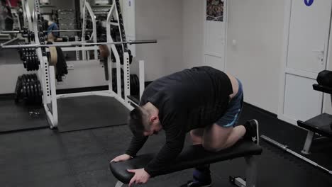 Cheerful-fat-man-performs-a-wrong-exercise-in-the-gym.-For-the-first-time-in-a-fitness-club