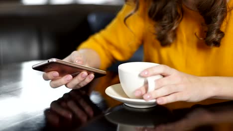 Mujer-bebiendo-café-en-café-y-usando-smartphone,-charlando-en-redes-sociales