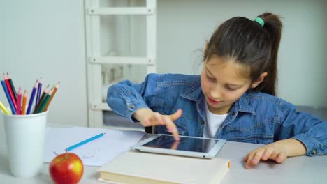 pequeña-niña-tocando-la-pantalla-de-la-tableta-mientras-juega-juegos-en-línea