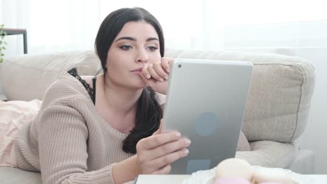 Relaxed-woman-using-digital-tablet-on-sofa