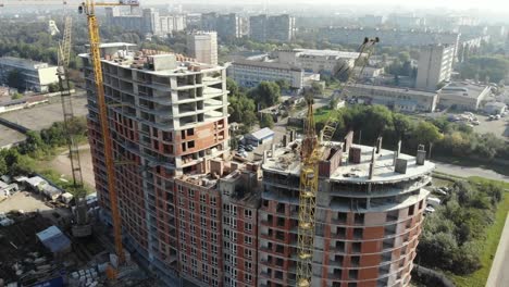 Una-vista-aérea-de-un-edificio-residencial-en-construcción.-Grúas-torre-que-trabajan-en-el-edificio.-4K