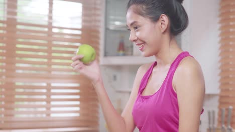 Asian-blogger-woman-make-vlog-how-to-diet-and-lost-weight,-Young-female-using-camera-recording-when-she-eating-fruits-in-the-kitchen.-Lifestyle-influencer-women-healthy-concept.