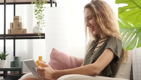 Glücklich-Teenager-Mädchen-mit-digitalen-Tablet-auf-dem-Sofa