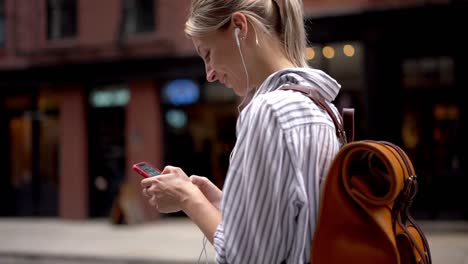 Efecto-de-cámara-lenta-de-chica-hipster-alegre-en-auriculares-electrónicos-buscando-contacto-en-las-redes-sociales