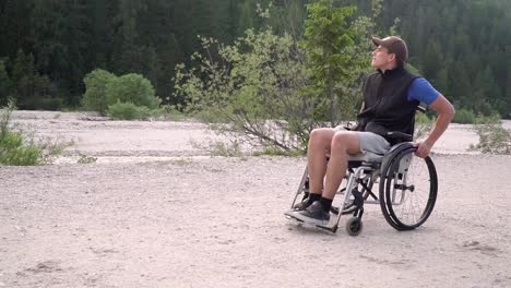 Slowmotion-of-disabled-young-student-man-in-a-wheelchair-observing-nature-around-him