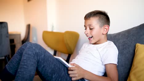 Young-boy-is-playing-games-on-his-tablet-at-home