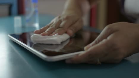 Woman-cleaning-and-disinfection-on-surfaces-of-digital-tablet.