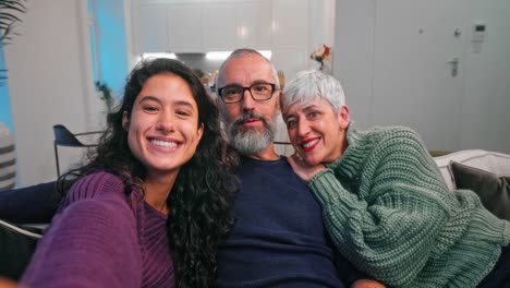 Daughter-taking-selfie-with-smartphone-with-parents-on-sofa