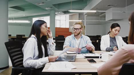 Businesswoman-boss-conveying-ideas-concerning-to-startup-project-to-group-of-diverse-colleagues,-sitting-at-table-in-office