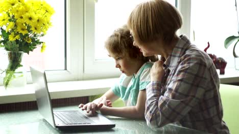 Die-Großmutter-und-der-Enkel-mit-Interesse-schauen-auf-den-Laptop-Bildschirm.