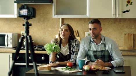 Young-attractive-couple-shooting-video-food-blog-about-cooking-on-dslr-camera-in-the-kitchen