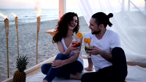 Sommerurlaub,-junge-Menschen-in-der-Liebe-trinken-bunten-Cocktails-mit-Obst,-romantisch-zu-zweit-am-tropischen-Strand