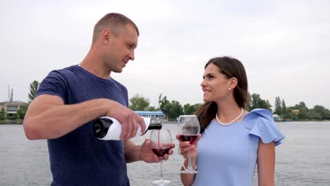 happy-couple-drink-red-tipple-in-background-sea,-romantic-twain-people-on-vacation,-glasses-in-hands-man-and-female