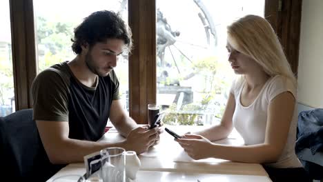 Pareja-de-adolescentes-con-problemas-de-relación,-redes-en-las-redes-sociales-usando-teléfonos-sentado-a-la-mesa-en-el-restaurante