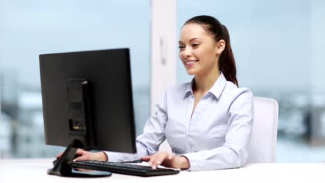 businesswoman-with-computer-showing-thumbs-up-at-office