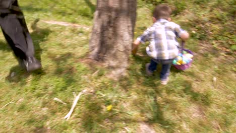 Emocionado-el-niño-corriendo-para-conseguir-un-huevo-de-Pascua-antes-de-otro-muchacho-en-cámara-lenta