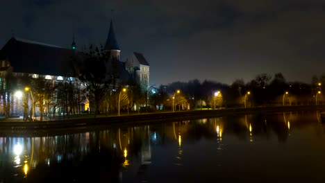 Illumination-on-a-historic-building.-Historic-Landmark.-Time-lapse.-Cathedral-of-Kant-in-Kaliningrad.-Old-medieval-castle-at-night-against-the-sky.-Timelapse.-City-park-with-a-river,-a-pond.