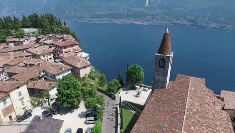 Italien.-Kirche-auf-dem-Berg-und-der-Altstadt-entfernt.-Panorama-des-wunderschönen-Gardasees-umgeben-von-Bergen.-Videodreh-mit-Drohne