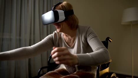 Aufgeregt,-ältere-Dame-im-Rollstuhl-Spaß-in-modernen-virtual-Reality-Kopfhörer