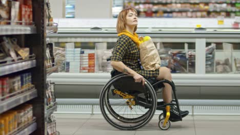 Señora-del-parapléjico-en-silla-de-ruedas-de-compras-en-la-tienda-de-comestibles