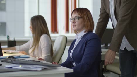 Mann-im-Rollstuhl-im-Büro-Kollegin-einschieben