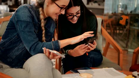 Junge-Teenager-Studentinnen-mit-Smartphones-im-Coffee-shop