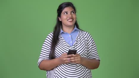 Young-overweight-beautiful-Indian-businesswoman-against-green-background