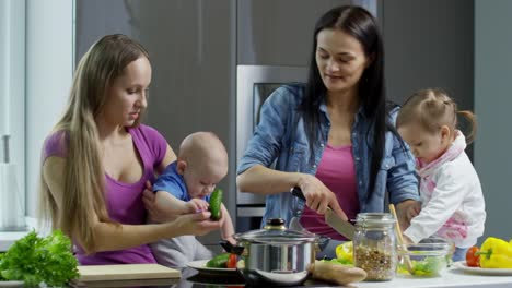 Weibliche-Ehepaar-mit-Kindern-machen-Salat-und-im-Chat