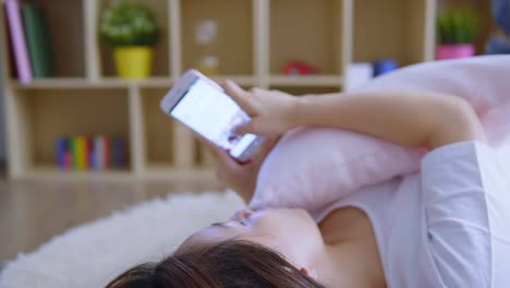 Asian-woman-using-cellphone-in-living-room