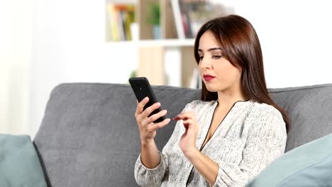 Woman-talking-on-phone-on-a-couch-at-home