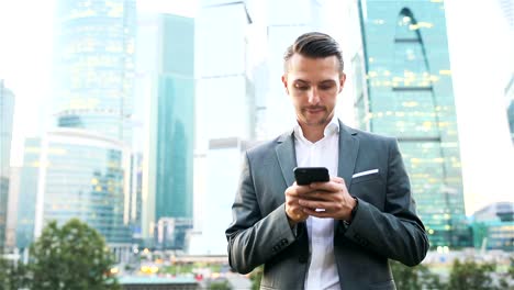 Young-caucasian-man-holding-smartphone-for-business-work.