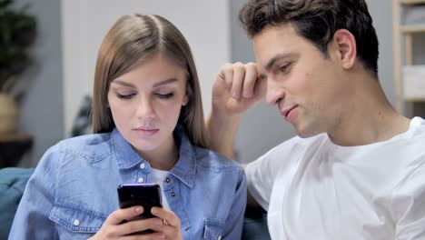 Hablando-joven-pareja-con-Smartphone-y-productos-en-línea-Disussing