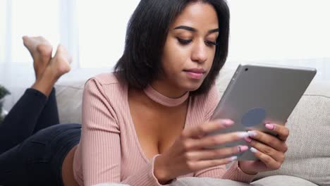 Teenage-girl-using-digital-tablet-on-sofa