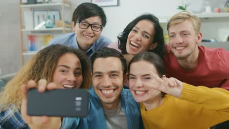 Zu-Hause-vielfältige-Gruppe-von-Freunden-tun-kollektive-Selfie,-Guy-Smartphone-hebt-Menschen-Lächeln,-lachen,-und-Ente-Lips.Young-Menschen-tun-Live-Stream-von-der-Party-nach-Hause.