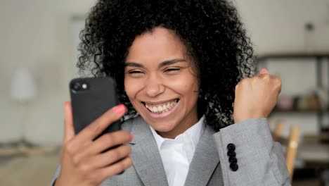 Empresaria-africana-disfrutando-del-éxito-durante-el-uso-de-smartphone