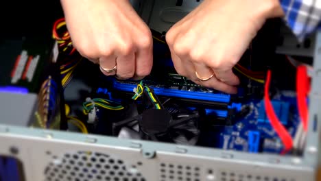 installing-RAM-computer-memory-lath-into-socket-by-expert-female-hand