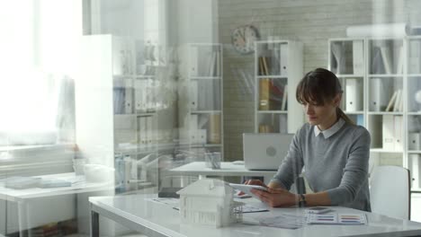 Female-Architect-Using-Digital-Tablet-at-Office-Desk