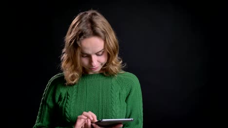 Closeup-portrait-of-adult-caucasian-woman-browsing-on-the-tablet-in-front-of-the-camera