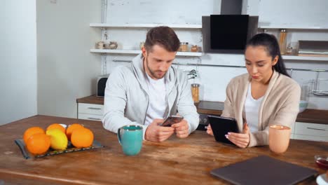 Husband-and-wife-sit-in-their-kitchen