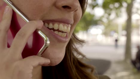 Closeup-shot-of-smiling-young-woman-talking-on-smartphone.