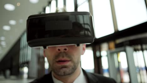 Close-up-shot-of-middle-aged-businessman-in-virtual-reality-headset-working-with-visualized-analytical-data,-tapping-and-swiping-information