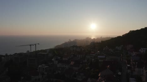 Toma-de-video-aéreo.-Atardecer-sobre-la-ciudad-de-Sochi.-Luz-de-noche.-Ciudad-balneario-en-el-mar-negro.